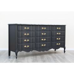 a black dresser with gold handles and drawers