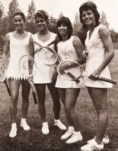 an old photo of four women holding tennis racquets