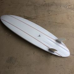 a white surfboard laying on the ground