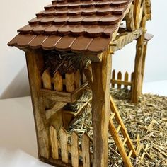 a bird house made out of wood sticks and straw with a roof that has birds in it