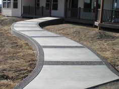 a walkway made out of concrete in front of a house with two porchs on each side