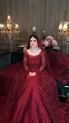 a woman in a red gown sitting on a couch