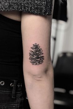 a pine cone tattoo on the arm