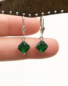 "Sterling Silver Emerald Princess Cut Dangle Earrings Minimalist and Simple Lightweight Earrings Stone: 7mm EmeraldCZ Metal: All components are made from solid .925 Sterling Silver Measurement: Earrings dangle approx. 1\" from top of ear wire *Earrings can be made with either lever backs or french hooks. *Choose Desired Earlier At Checkout You can find other Earrings in my shop here https://www.etsy.com/shop/LinksAndStones?ref=seller-platform-mcnav&section_id=24232772 Please feel free to Con May Birthstone Crystal Drop Earrings, Classic Emerald Dangle Jewelry, May Birthstone Drop Earrings With Ear Wire, Dangle Earrings With May Birthstone, Single Dangle Earring For May Birthstone, Hypoallergenic May Birthstone Drop Earrings, Hypoallergenic Drop Earrings For May Birthstone, Gift Emerald Crystal Dangle Earrings, Classic Nickel-free Dangle Crystal Earrings