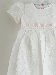 Beautiful and elegant baby girls' lace baptism dress. Two-piece set including a delicately embroidered short-sleeve gown with matching lace bonnet. Complete with a linen and cotton blend liner, to ensure comfort. Feel free to add one of our adorable headbands to complete the look. Elegant Fitted Pink Baptism Dress, Short Sleeve Lace Dress For Confirmation, Fitted Lace Bodice Dress For First Communion, Short Sleeve Lace Confirmation Dress, Fitted Short Sleeve First Communion Dress, Lace Dress For First Communion With Short Sleeves, Fitted Short Sleeve Baptism Dress, Fitted First Communion Dress With Short Sleeves, First Communion Dresses With Lace Trim And Short Sleeves