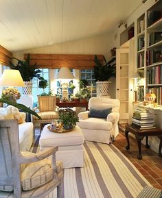 a living room filled with furniture next to a book shelf covered in lots of books