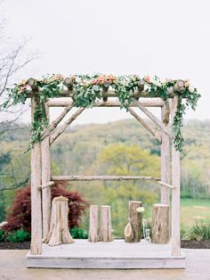 a wooden structure with flowers and greenery on it