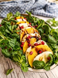 a salad with peaches and pomegranate on it