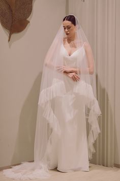 a woman in a white wedding dress and veil