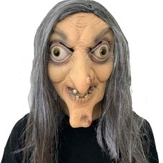 an old woman with grey hair and big eyes is wearing a creepy mask on her face