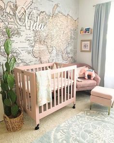 a baby's room with a map on the wall and a pink crib