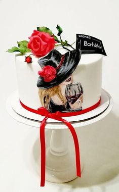 a cake decorated with a woman's face and a red ribbon around the edge