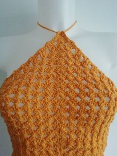 an orange crocheted top on a mannequin