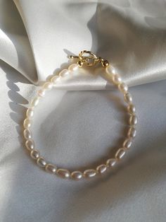 This Genuine Freshwater Pearl Bracelet/Modern Pearl Jewelry/Seed White Pearl Bracelet/Tiny Pearl Bracelet/Golden Toggle Pearl Bracelet is made with genuine seed freshwater pearl beads and a golden toggle. The pearl is rice-shaped, which creates a slim and modern feeling. The toggle adds more delicacy to it. This bracelet can be worn alone or be stacked with other golden bracelets to create a casual and modern feeling. It is a perfect gift for yourself or your loved ones. Domestic shipping is inc Elegant Chain Bracelet With Clasp As Gift, Classic Adjustable Chain Bracelet With Pearl Charm, Elegant Charm Bracelet With Toggle Clasp As Gift, Elegant Charm Bracelet With Toggle Clasp, Classic Bracelets With Toggle Clasp As Gift, Adjustable Chain Bracelet With Toggle Clasp As Gift, Elegant Beaded Bracelets With Lobster Clasp As Gift, Elegant Beaded Bracelets With Lobster Clasp For Gifts, Everyday Single Strand Bracelets