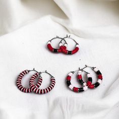 Show your team spirit and represent your game day team colors with these stunning red, white, and black heishi bead stainless steel hoop earrings.  - Available in 3 sizes: 1", 1.5" and 1.75" - Three unique designs to choose from Make a statement and cheer on your team in style with these trendy earrings. Perfect for game day or any occasion. Grab a pair now and show your support! Heishi Jewelry, Spirit Game, Bead Hoop Earrings, Team Mom, Beads Bracelets, Red Jewelry, Bracelet Ideas, Trendy Earrings, Heishi Beads