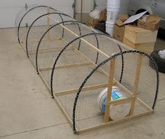 a set of three cages sitting on top of a floor next to a garage door