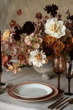 the table is set with silverware and flowers