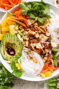 a bowl filled with rice, carrots, avocado and other veggies