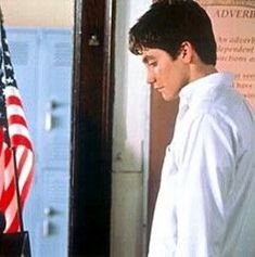 a young man standing in front of an american flag