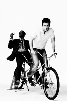 black and white photograph of two men on a bicycle with one holding the handlebars