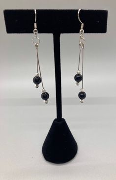 These earrings are black crystal pearls bracketed by silver beads, hanging on silver-filled wire.  One dangle is 1 1/2 inches, and the other is 2 inches. Elegant Adjustable Wire Wrapped Chandelier Earrings, Elegant Wire Wrapped Round Crystal Earrings, Elegant Wire Wrapped Crystal Earrings With Round Beads, Elegant Silver Beaded Earrings Wire Wrapped, Elegant Silver Beaded Earrings With Wire Wrapping, Adjustable Dangle Beaded Earrings With Pearl Drop, Adjustable Pearl Drop Dangle Beaded Earrings, Adjustable Pearl Drop Beaded Dangle Earrings, Silver Adjustable Long Drop Beaded Earrings