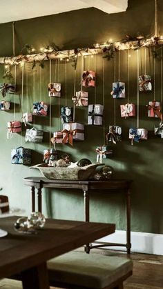 a dining room with green walls and pictures hanging on the wall, along with a wooden table