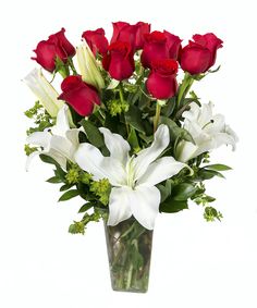 a vase filled with red roses and white lilies