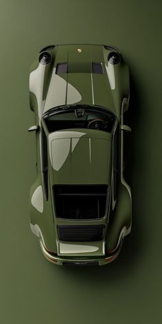 an overhead view of a sports car on a green background with the hood up and tail lights down