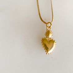 Sacred heart gold charm necklace. Sacred heart charm is 14K gold plate over sterling silver. The symbol represents boundless and passionate love for all of humanity. The flame or light surrounding the heart, signifies the divine light of love. It also symbolizes love for one another. Charm measures about 3/4”. Stamped 925. Hangs on 14K Gold filled (14KTGF) herringbone chain. Measures 18”. BelleStyle logo tag at clasp. Comes in a box inside a linen travel pouch. Made in USA. Waterproof. Symbolic Yellow Gold Heart Jewelry, Everyday Spiritual Heart Necklace, Everyday Spiritual Heart-shaped Necklace, Symbolic Gold Jewelry With Heart Charm, Symbolic Gold Jewelry For Valentine's Day, Spiritual Yellow Gold Charm Necklace For Her, Symbolic Heart Pendant Necklace With Charms, Symbolic Necklace With Heart Charm For Anniversary, Spiritual Heart-shaped Charm Necklaces