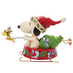 a figurine of a snoopy dog on a sleigh with christmas decorations