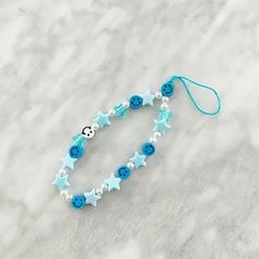 a blue and white beaded bracelet with buttons, beads and star shapes on it