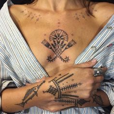 a woman with tattoos on her chest and arm