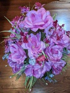 a bouquet of purple flowers sitting on top of a wooden table