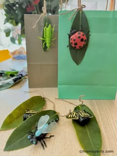 some bugs are sitting on top of green leafy plants in front of bags with ladybugs hanging from them