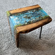 a table made out of wood and glass with rocks in it on carpeted area