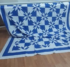 a blue and white quilt on the floor