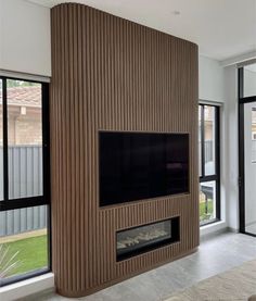 a living room with a flat screen tv mounted to the side of a wooden wall