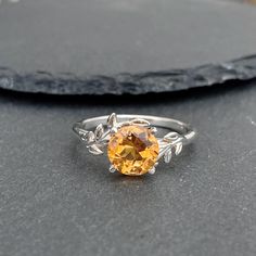 This Citrine Ring features a natural design and showcases a high-quality 8mm citrine stone. If you are looking for a November Birthstone Ring, Yellow Quartz Ring Silver, or Natural Inspired Ring this ring will be a perfect choice.  Why this citrine ring:   - Unique design and handmade from natural citrine. - This gorgeous unique ring is 100% handcrafted by an artisan. - Citrine is believed to bring prosperity, joy, and positive energy, making this piece an ideal gift for those born in November. November Birthstone Ring Topaz, Ring Tree, Topaz Yellow, November Birthstone Ring, Yellow Quartz, Citrine Stone, Citrine Ring, November Birthstone, Tree Leaves