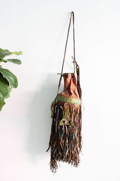 The Tuareg were traditionally a nomadic culture that traveled in camel caravans along trade routes in the Saharan desert until the mid-20th century. This intricately handcrafted leather drawstring pouch has a braided strap that can be tightened to secure the opening of the bag. Lengthy and decorative fringe accents cascade from the bottom of the pouch, giving it vibrant and dramatic movement when carried. In good condition with beautiful leather patina. Entire length measures approx. 52 in. from Nomadic Culture, Leather Drawstring Pouch, Drawstring Bucket Bag, Braided Strap, Drawstring Pouch, Handcrafted Leather, The Pouch, Macrame Plant Hanger, Plant Hanger