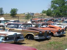 many old cars are parked in a field