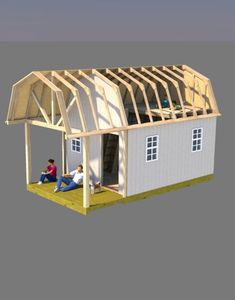 two people sitting on the grass in front of a house with a roof that is being built