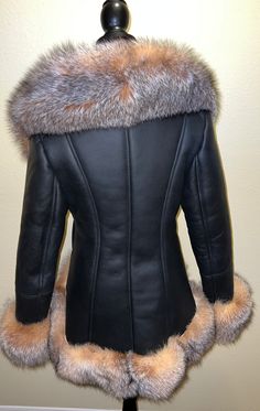 Our gorgeous high low shearling is in black with stunning crystal fox fur. This coat has a zip closure and two pockets. This shearling runs true to size. Fitted Black Sheepskin Fur Coat, Black Sheepskin Fur Coat With Faux Fur Lining, Fitted Luxury Fur Coat With Faux Fur Lining, Fitted Shearling Fur Coat With Faux Fur Lining, Luxury Black Fur Coat With Feather Trim, Black Leather Fur Coat With Faux Fur Trim, Elegant Black Sheepskin Fur Coat, Luxury Sheepskin Fur Coat With Faux Fur Trim, Luxury Black Sheepskin Fur Coat