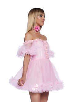 This mini dress has a tulle construction, an off the shoulder design with fabric lace and bow detailing, a ruffled trim, and a back zipper closure. Dolls Kill Pink Dress, Pink Prom Dress With Attached Cancan, Spring Corset Dress With Ruffles And Tulle, Spring Tulle Corset Dress With Ruffles, Flirty Pink Corset Dress With Ruffles, Feminine Party Dress With Attached Cancan, Feminine Dress With Attached Cancan For Party, Pink Ruffled Mini Dress For Prom, Pink Ruffled Dress For Homecoming