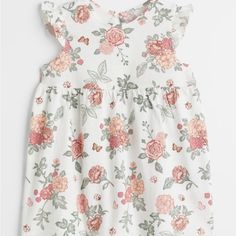 Never Worn! Ntw! Size 12m Sleeveless Dress In Soft Cotton Jersey. Ruffles At Front Extending Over Shoulders To Back, Small Opening At Back Of Neck With Button, And Gathered Seam Above A Flared Skirt. Compositioncotton 100% Floral Print Sleeveless Playwear Dresses, Casual H&m Dresses With Ruffles, White Ruffled H&m Dresses, White Ruffled Dresses By H&m, H&m White Ruffled Dresses, H&m Pink Sleeveless Dress, H&m Short Sleeve Dresses With Ruffles, White Cotton H&m Dresses, White Sleeveless Playwear Dress