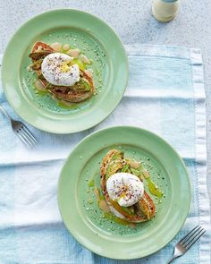 two green plates topped with sandwiches on top of a blue cloth next to a fork