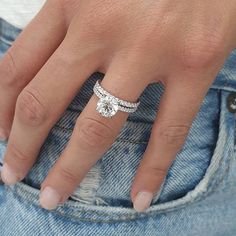 a close up of a person's hand with a diamond ring on their finger