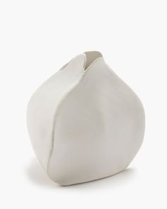 a white vase sitting on top of a table