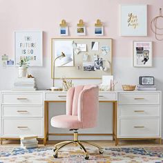 a pink chair sitting in front of a desk with a mirror and pictures on the wall