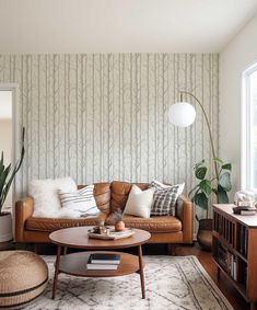 a living room filled with furniture and a large tree wallpaper behind the couches