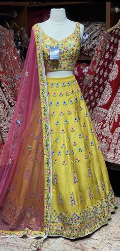 Saffron yellow lehenga elaborate work done all over the lehenga with multicolor resham detailing in floral design and highlighted with flux mirror and zari embroidery. Accomplished with similarly embroidered blouse and Look outstanding by styling a contrasting pink cut net dupatta. A saffron yellow that is not only dreamy but whimsical as well. Fabric : Silk Size: 38 Ready to Ship! Navratri Tissue Silk Sharara With Resham Embroidery, Eid Anarkali Lehenga In Chanderi, Bollywood Style Resham Embroidered Anarkali For Festivals, Bollywood Style Anarkali Set With Resham Embroidery For Festivals, Festive Kundan Anarkali Set With Dori Work, Designer Art Silk Anarkali Set With Mirror Work, Designer Anarkali Set With Resham Embroidery For Festivals, Bollywood Chanderi Sharara With Dori Work, Anarkali Semi-stitched Choli With Zari Work